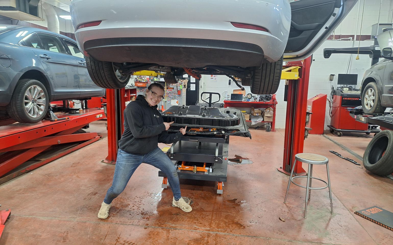 Student smiles while working in the auto lab.