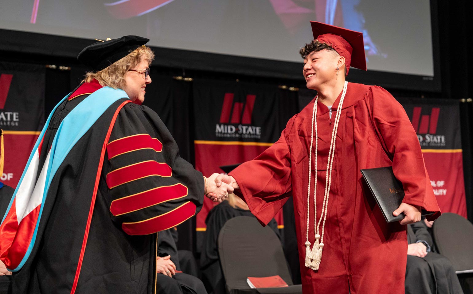 Mid-State Technical College President Dr. Shelly Mondeik congratulates a graduate during the presentation of diplomas at Mid-State’s fall commencement on the Wisconsin Rapids Campus, Dec. 13, 2025.